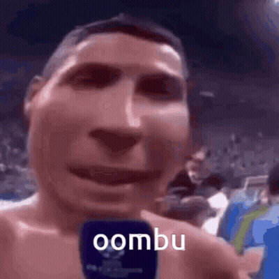 Shirtless Man Holding Microphone Says Oombu GIF