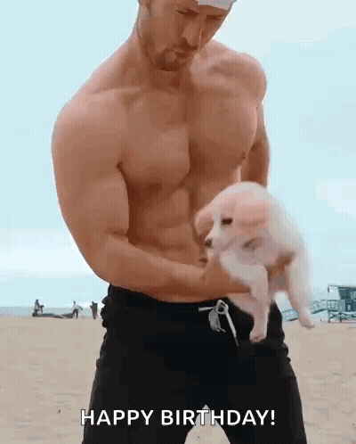 Shirtless Man Holding Puppy On Beach Saying Happy Birthday GIF