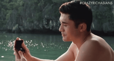 Shirtless Man Holding Ring On Beach GIF