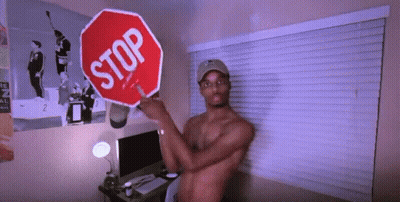 Shirtless Man Holding Stop Sign In Front Of Window GIF