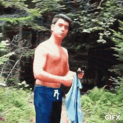 Shirtless Man Holding Towel in Woods