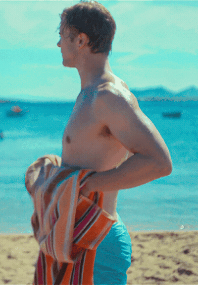 Shirtless Man Holding Towel Over Shoulder On Beach GIF