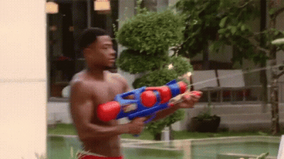 Shirtless Man Holding Water Gun By Pool GIF