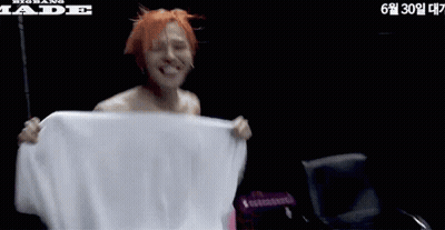 Shirtless Man Holding White Towel Next To Jade Chair GIF