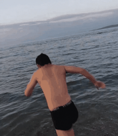 Shirtless Man In Black Shorts Jumping Into Water GIF