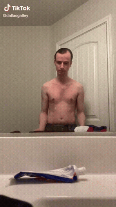 Shirtless Man In Front Of Bathroom Mirror With Toothpaste GIF