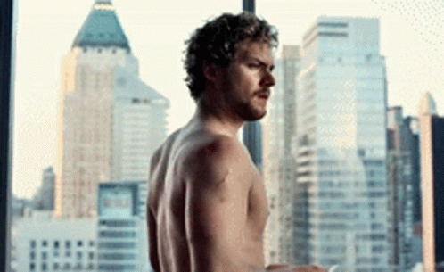 Shirtless Man In Front Of City Skyline GIF