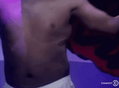Shirtless Man In Front Of Comedy Sign GIF