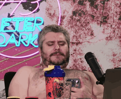 Shirtless Man In Front Of Peter Dark Neon Sign GIF