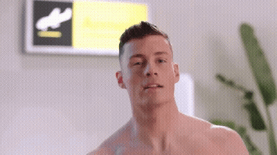 Shirtless Man In Front Of Sign Saying A GIF