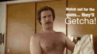 Shirtless Man In Front Of Wall Saying Watch Out For The Guns They'll Getcha GIF