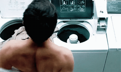 Shirtless Man In Front Of Washing Machine With Instructions GIF