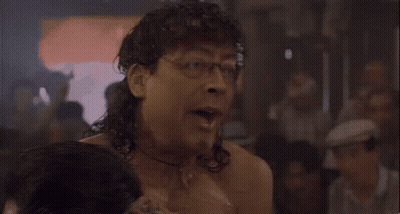 Shirtless Man In Glasses And Headband Beside Woman GIF