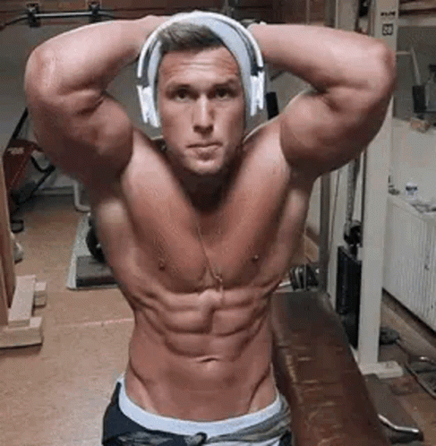 Shirtless Man In Headphones Standing In Gym Arms Over Head GIF