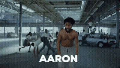 Shirtless Man In Parking Garage Surrounded By People GIF