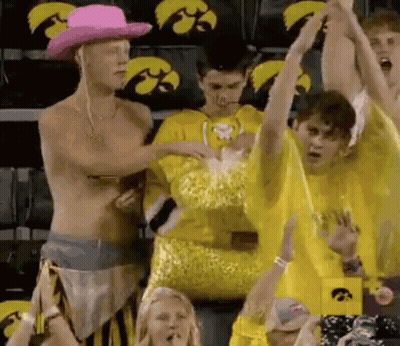 Shirtless Man In Pink Cowboy Hat In Front Of Yellow Shirt Crowd GIF