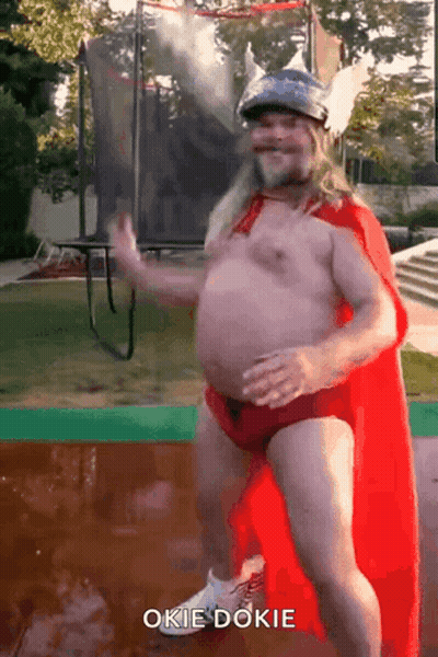 Shirtless Man In Red Cape And Helmet Dancing On Trampoline Saying Okie Dokie GIF