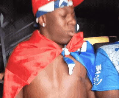 Shirtless Man in Red White Blue Cape and Hat With Letter A