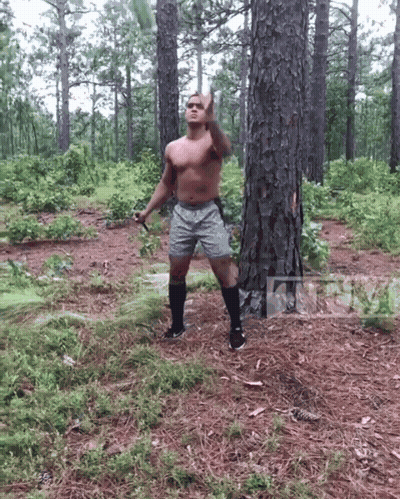 Shirtless Man In Woods Holding Sword Giving Middle Finger GIF