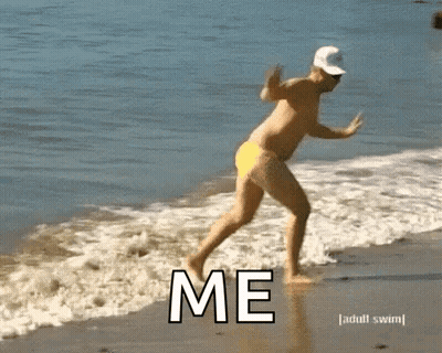 Shirtless Man In Yellow Swim Trunks Running Into Ocean Saying Me GIF