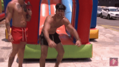 Shirtless Man Jumping In Front Of Bouncy House GIF