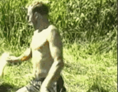 Shirtless Man Kneeling In Grass GIF