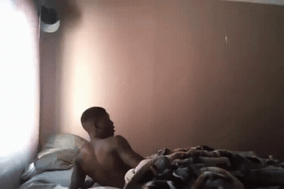 Shirtless Man Laying On Bed In Bedroom GIF