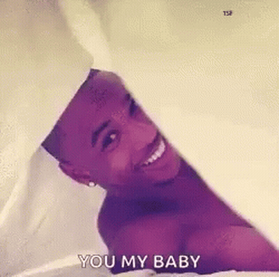Shirtless Man Laying On Bed Smiling Holding White Sheet GIF