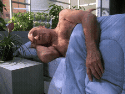 Shirtless Man Laying On Bed With Blue Blanket GIF