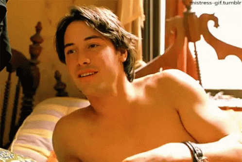 Shirtless Man Laying On Bed With Striped Pillow GIF