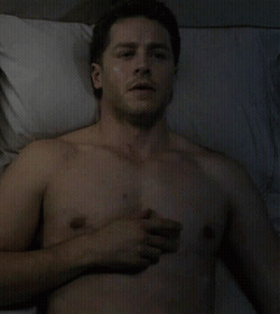 Shirtless Man Lying In Bed With Hand On Chest GIF