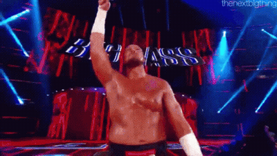 Shirtless Man On Stage With Arm Raised GIF