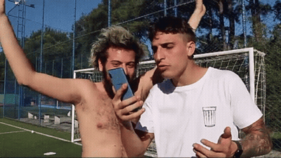 Shirtless Man Photographing Another Shirtless Man With Trash Can GIF