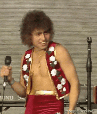 Shirtless Man Singing In Red Vest With Flowers GIF