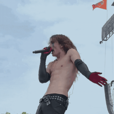 Shirtless Man Singing Into Microphone With Black Gloves GIF