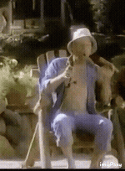 Shirtless Man Sitting In Chair With Cane And Microphone GIF