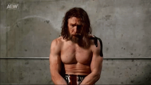 Shirtless Man Sitting In Front Of AEW Logo GIF