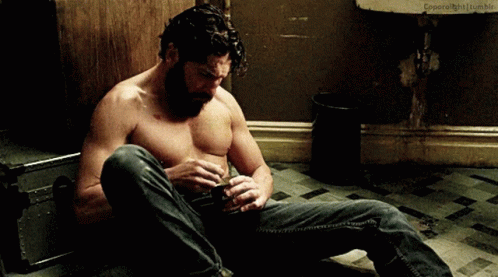 Shirtless Man Sitting In Front Of Sink GIF