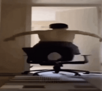 Shirtless Man Sitting In Office Chair With Arms Outstretched GIF
