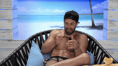 Shirtless Man Sitting In Wicker Chair With Beach Scene GIF