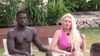 Shirtless Man Sitting Next To Woman In Purple Dress GIF