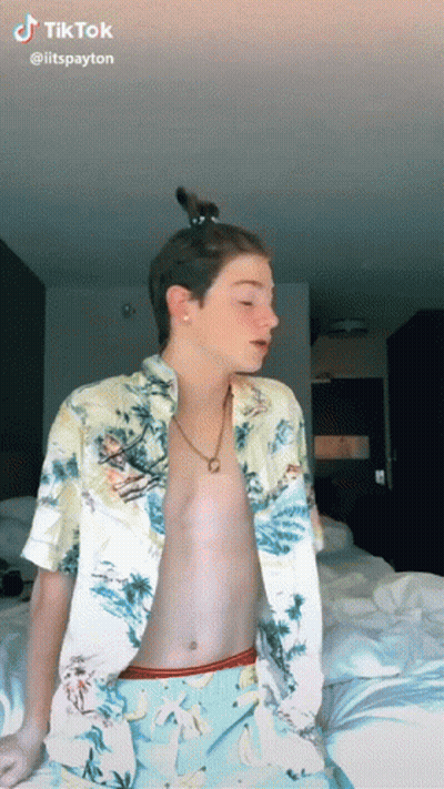 Shirtless Man Sitting On Bed With Cat In Hair GIF