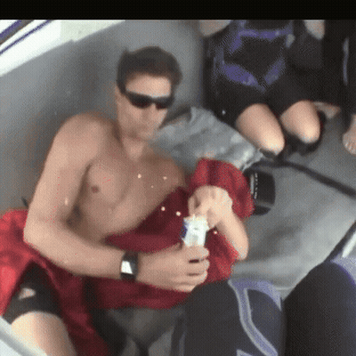 Shirtless Man Sitting On Boat Holding Bottle GIF