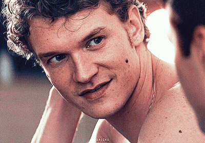 Shirtless Man Smiling At Camera While Another Looks On GIF