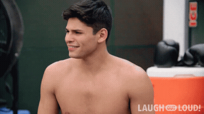 Shirtless Man Smiling In Front Of Laugh Out Loud Sign GIF