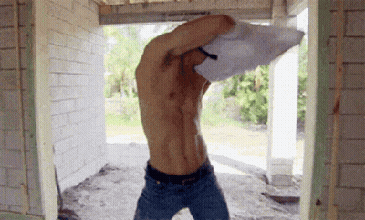 Shirtless Man Standing By Brick Wall GIF