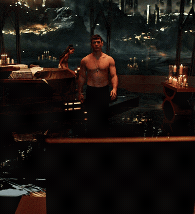 Shirtless Man Standing By Candlelit Window GIF
