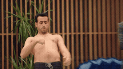 Shirtless Man Standing By Wooden Fence GIF