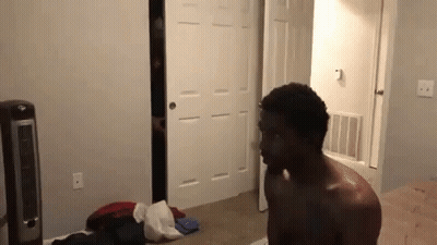 Shirtless Man Standing In Bedroom Next To Fan And Closet GIF