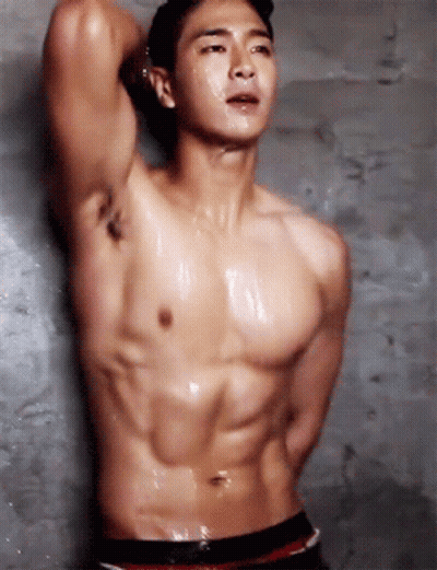 Shirtless Man Standing In Front Of Concrete Wall GIF
